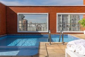 a swimming pool with a view of a building at Regent Park Suite Hotel in Sao Paulo