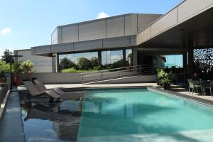 una casa con piscina delante en Indaiá Park Hotel, en Campo Grande