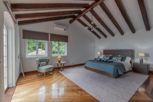 a bedroom with a bed and a chair and windows at Vila Islet View in Vila Franca do Campo +33 photos