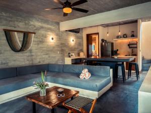 a living room with a blue couch and a table at Villa Gato Surf Houses grande 4-6 personas, Starlink, AC, alberca, 50 m del spot La Saladita in La Salada
