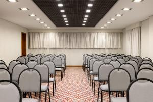 an empty room with rows of chairs in a classroom at Regent Park Suite Hotel in Sao Paulo +35 photos