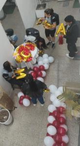 un gruppo di persone che si trovano intorno a un tavolo con palloncini di Hostel Barranco Angeles a Lima