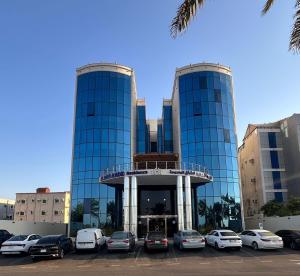 a building with cars parked in a parking lot at شقق الريم الجديد للشقق المخدومة Al Reem Al Jadid residence in Yanbu