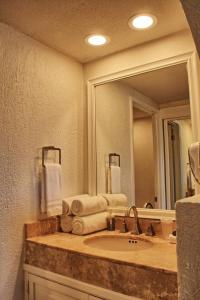 a bathroom with a sink and a large mirror at Princesa -C206- Arcade Game -Experience Rocky Point- in Puerto Peñasco