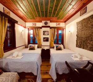 a room with two beds with yellow curtains at Meliteion Traditional Hotel in Asprangeloi