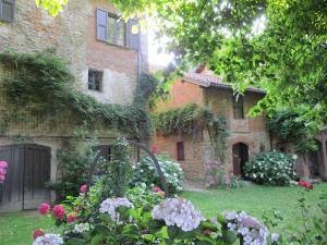 a garden with flowers in front of a building at Castello di Tagliolo Wine Resort in Tagliolo Monferrato