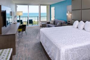 默特尔比奇Cabana Shores Hotel的带大床和阳台的酒店房间