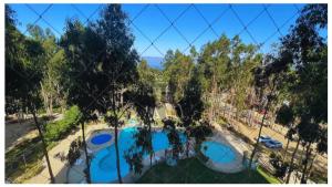サンアントニオにあるVR | Algarrobo Playa Mirasol 5PAX mar cerca, piscina, hermosa decoración, parking freeの塀越しにスイミングプールを望む +15枚の写真