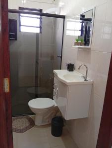 a bathroom with a toilet and a sink and a shower at Casa aconchegante privativa in Limeira