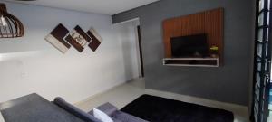 a living room with a couch and a television at Casa aconchegante privativa in Limeira