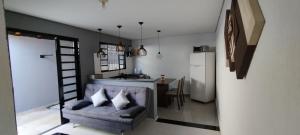 a living room with a couch and a kitchen at Casa aconchegante privativa in Limeira