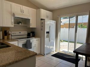 una cucina con mobili bianchi e un frigorifero bianco di Quiet Cozy Private Room Perfect for Work or Vacation RM2 shared home a Sarasota