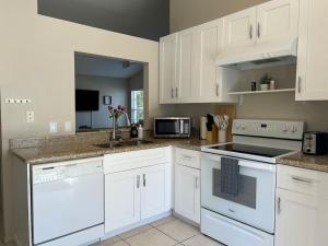 a kitchen with white cabinets and white appliances at Relaxing Getaway in Sarasota Great Location Whole House in Sarasota