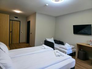 a hotel room with two beds and a flat screen tv at Хотел Ресторант Ваката in Teteven +14 photos