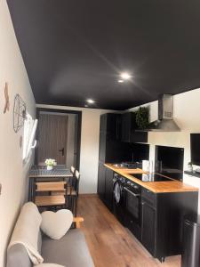 a kitchen with a couch and a table in a room at Au cœur des Vosges in Thiéfosse +3 photos