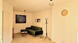 a living room with a green couch and a lamp at Appartement 2 chambres climatisé in Saint-Ambroix