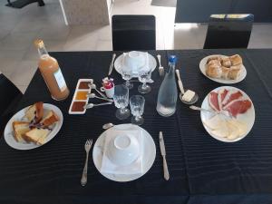 a black table topped with plates of food and drinks at Villa Le Phoenix in Aux-Aussat