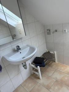 a white bathroom with a sink and a mirror at Ferienwohnung Madeleine in Haiger