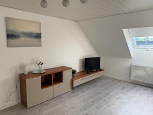 a living room with a tv on a cabinet at Ferienwohnung Madeleine in Haiger