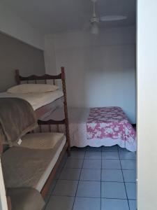 Cette petite chambre comprend 2 lits superposés et du carrelage. dans l'établissement Apartamento de 35 m2 em Itapema, à Itapema