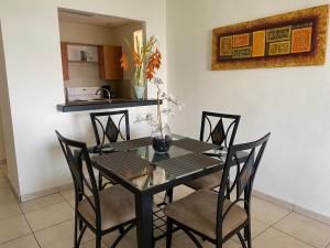 a black dining room table with chairs and a kitchen at Beatiful Condo in Escalon near WTC building and Masferrer in San Salvador +6 photos