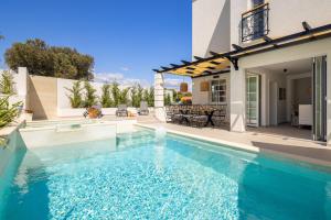 una piscina davanti a una casa di Luxury 4BR Villa Heated Pool, Just 100m to Sea a Ražanj