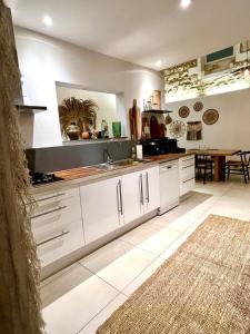 a kitchen with white cabinets and a table and a rug at Maison de caractère - Jardin - Proche Angoulême in Saint-Yrieix-sur-Charente +6 photos
