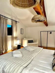 a bedroom with a large bed and a chair at Maison de caractère - Jardin - Proche Angoulême in Saint-Yrieix-sur-Charente