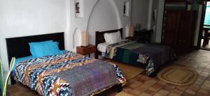 a bedroom with two beds in a room at AylluWasi Guesthouse in Otavalo