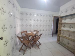 a dining room with a wooden table and chairs at Quarto Compartilhado na Praça de Serra Grande in Uruçuca +5 photos