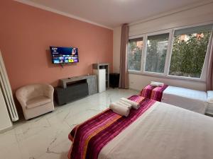 a hotel room with two beds and a flat screen tv at Luna Guest House in Pisa