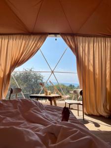 a bed in a tent with a table and chairs at Kol Breeze in Korumdy