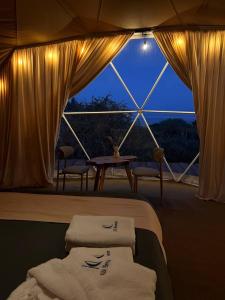 a room with a bed and a window with towels at Kol Breeze in Korumdy