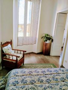 a bedroom with a bed and a chair and a window at Ausra in Olbia