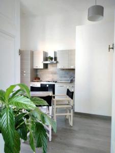 a kitchen with white cabinets and a table and a plant at Ausra in Olbia