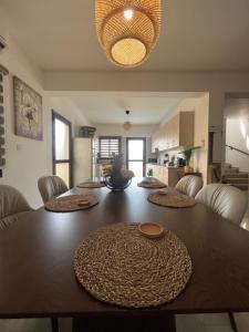 a large wooden table in a living room with a kitchen at Dene Hollow kapparis in Paralimni