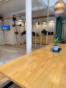 a large wooden table in a room with potted plants at Hostel 360 Patagonia in El Bolsón