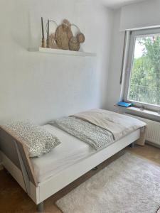 een bed in een witte kamer met een raam bij REHBLICK Ferienwohnung in Trösel