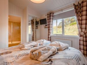 une chambre avec un grand lit avec une fenêtre dans l'établissement 2 Bed in Isle of Skye 75068, à Portree