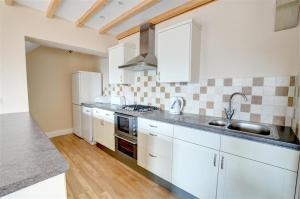 una cucina con mobili bianchi e un lavandino di Weavers Cottage a Cowling Altre 7 foto