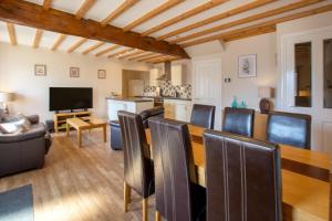 un soggiorno con tavolo da pranzo e sedie di Weavers Cottage a Cowling
