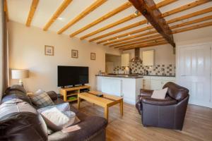 un soggiorno con un divano e una TV di Weavers Cottage a Cowling