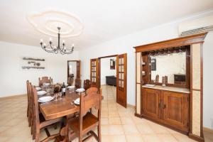a dining room with a table and a kitchen at Villa Entrecolinas in São Bartolomeu de Messines