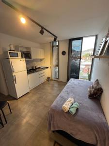 a bedroom with a large bed with two towels on it at Departamento en el centro - Lake Tower in Villa Carlos Paz