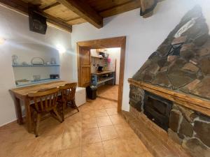 ein Wohnzimmer mit einem Steinkamin und einem Tisch und Stühlen in der Unterkunft Zázrak Wellness in Banská Štiavnica + 26 Fotos