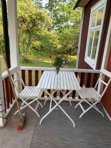 a white bench on a porch with a vase of flowers at Large house in rosenfors near Borgholm for rent in Borgholm