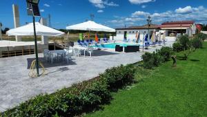 a pool with tables and chairs and umbrellas at Le follie in Maddaloni