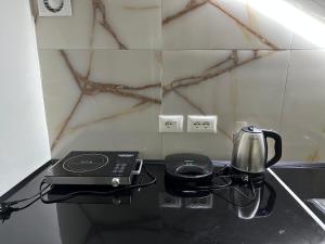 a counter with a coffee maker and a tea kettle at Xhorxhia &Room in Tirana