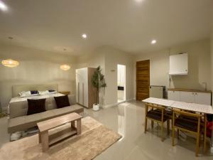 a living room with a bed and a dining room at TIL DAWN Phuket in Karon Beach