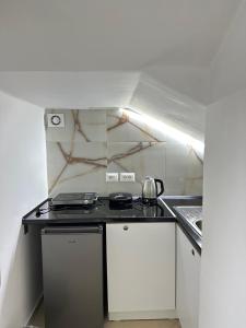 a small kitchen with a stove and a sink at Xhorxhia &Room in Tirana